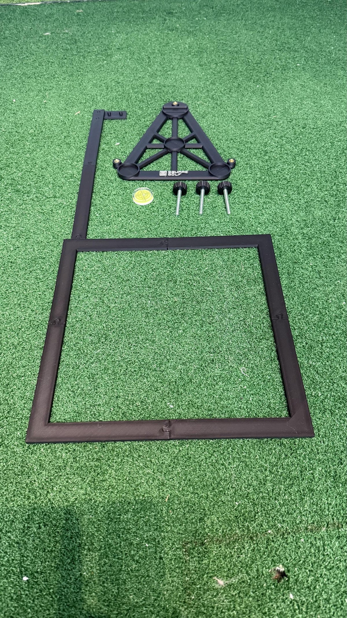Example of the printed Omni base, frame parts, M6 foot knobs, screws and bubble level laid out on green turf. This listing supplies digital model files only.
