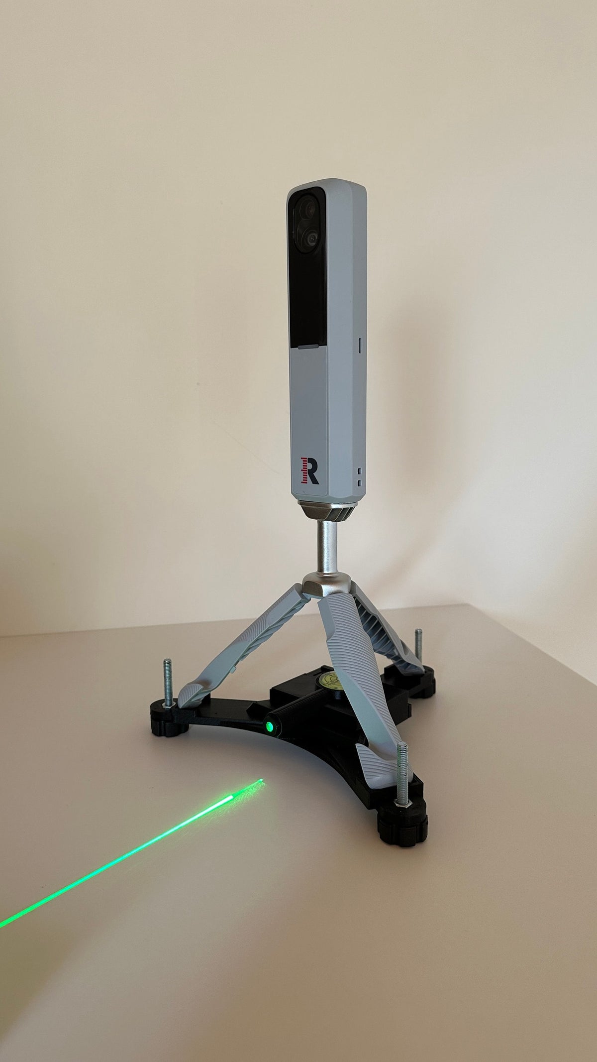 Rapsodo MLM2PRO on the rechargeable leveling stand projecting a green line