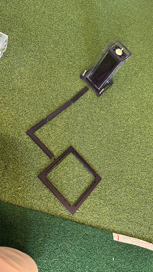 Square Golf protective case with ball positioning arm and square frame laid out on a golf mat